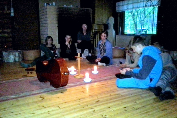 Nuoria istumassa takkatuvan lattialla