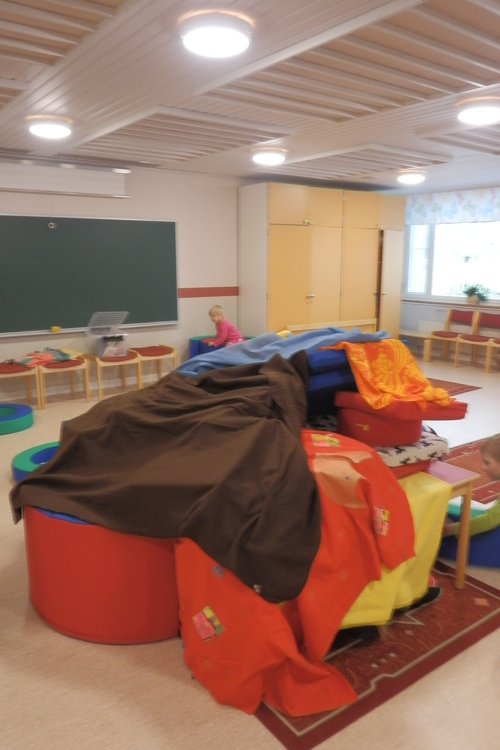 Pöytien ja tuolien päälle aseteltuja huopia ja pari lasta