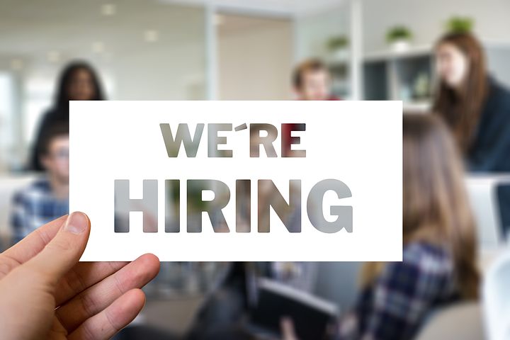 käsi joka pitelee tekstiä we're hiring